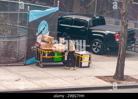Un travailleur d’Amazon trie les livraisons sur le trottoir pour les distribuer dans le quartier de Chelsea à New York le jeudi 8 février 2024. (© Richard B. Levine) Banque D'Images