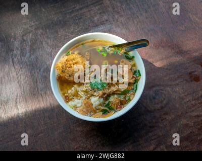 Soto Ayam, une soupe traditionnelle indonésienne au poulet sur une table en bois. Banque D'Images