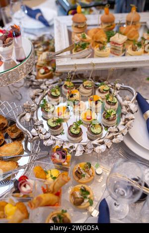 Une table joliment décorée est chargée d'une variété de délicieux apéritifs et desserts et élégamment sertie avec des nappes et des serviettes blanches, creat Banque D'Images