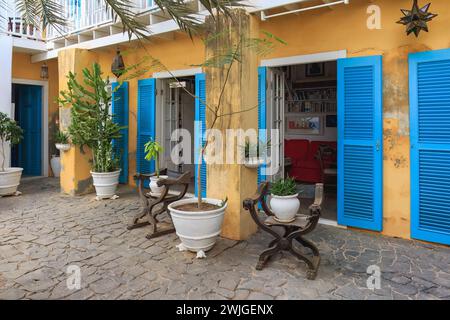 Boa Vista, Cap-Vert- 22 mars 2018 : un café-jardin confortable à Sal Rei, avec des meubles en bois rustiques et des volets bleus vibrants. Banque D'Images
