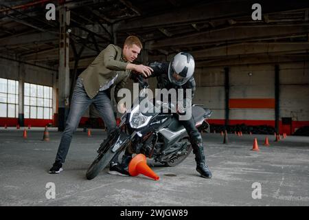 Élève tombant de moto à la classe de formation en auto-école Banque D'Images