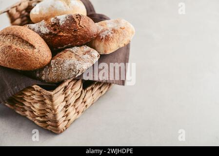 Assortiment de produits de boulangerie comprenant des pains, baguette et petits pains dans le panier, vue de dessus Banque D'Images