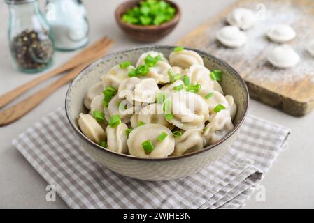 Pelmeni russe, boulettes avec de la viande, du beurre et des herbes sur un fond clair gros plan Banque D'Images