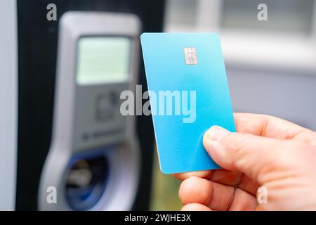 homme en gros plan tenant une carte bancaire pour le paiement du carburant, les services automobiles et les dépenses de carburant associées à l'utilisation des cartes bancaires, la protection des données financières et Banque D'Images