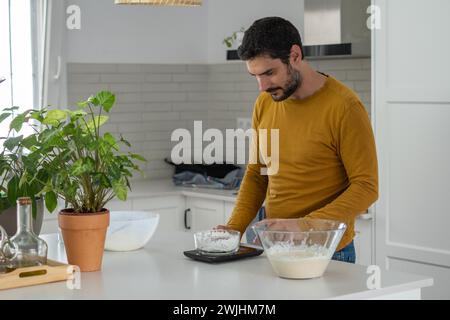 Jeune homme faisant du pain maison dans sa cuisine Banque D'Images