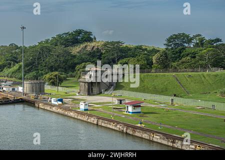 Canal de Panama, Panama - 24 juillet 2023 : les écluses de Miraflores ont quitté la chambre en direction nord de la rive verte sous le ciel bleu nuageux, tour de guet et autre bâtiment. G Banque D'Images