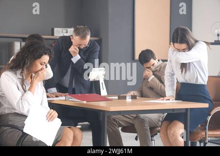 Les gens d'affaires étouffant avec la fumée dans l'immeuble de bureaux en feu Banque D'Images