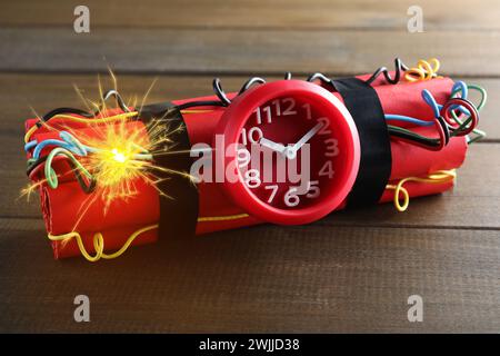 Bombe à retardement dynamite avec des fils brûlants sur une table en bois Banque D'Images