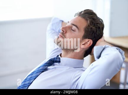 Homme d'affaires, moment et se détendre respirant dans le bureau pour la gestion du stress, le soulagement et l'équilibre pour la paix tout en travaillant. Homme, calme et yeux fermés Banque D'Images