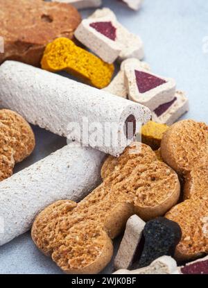 collection de diverses friandises et produits à mâcher pour chiens sur une surface grise tachetée avec espace de copie Banque D'Images