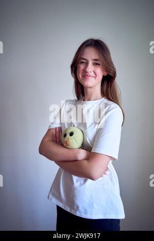 une adolescente avec son jouet préféré de l'enfance, une tortue en peluche verte Banque D'Images