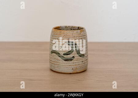 Tasse en céramique faite à la main avec vague sur table en bois. Photo de haute qualité Banque D'Images