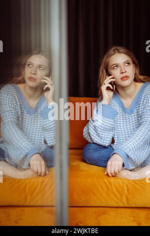 Jeune femme parlant au téléphone, appelant ses proches Banque D'Images