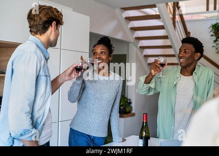 Group of friends toasting with wineglasses while hanging indoors Stock Photo