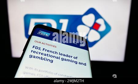 Smartphone avec le site de la société française de loterie française des Jeux (FDJ) devant le logo de l'entreprise. Concentrez-vous sur le coin supérieur gauche de l'écran du téléphone. Banque D'Images