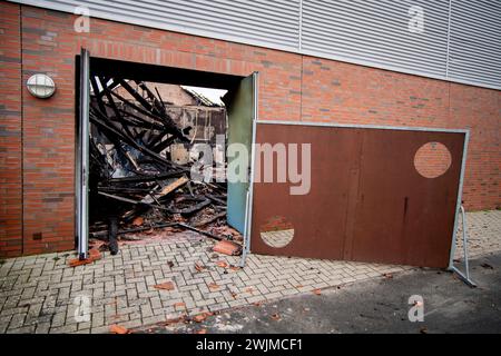 Neermoor, Allemagne. 16 février 2024. Un mur de but se dresse devant le gymnase incendié de l'école primaire à Neermoor. Un incendie a détruit le gymnase de l'école primaire de Neermoor hier soir. Des vents violents et des matériaux de construction facilement combustibles dans le hall ont fait que le feu s'est propagé en un incendie plus grand avec des étincelles volantes et de la fumée lourde. Crédit : Hauke-Christian Dittrich/dpa/Alamy Live News Banque D'Images