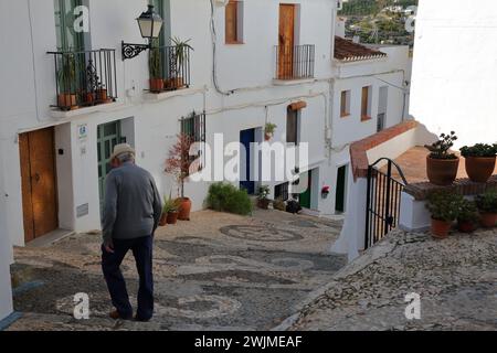 FRIGILIANA, ANDALOUSIE, ESPAGNE - 24 DÉCEMBRE 2023 : une ruelle pavée étroite et escarpée pittoresque avec des petites maisons traditionnelles blanchies à la chaux Banque D'Images