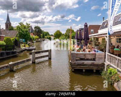 Les gens se relaxent sur la terrasse du restaurant le long du canal dans le centre de Heeg, Frise, pays-Bas Banque D'Images