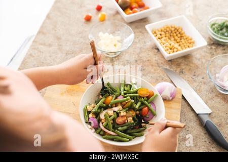 Jeune femme biraciale de taille plus profite d'un repas sain à la maison inchangé Banque D'Images