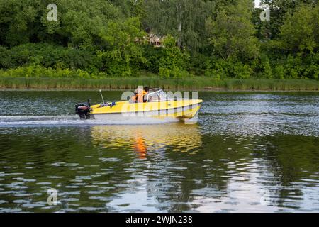 Un bateau à moteur jaune navigue le long de la rivière russe Yaroslavl le 10 août 2023 Banque D'Images