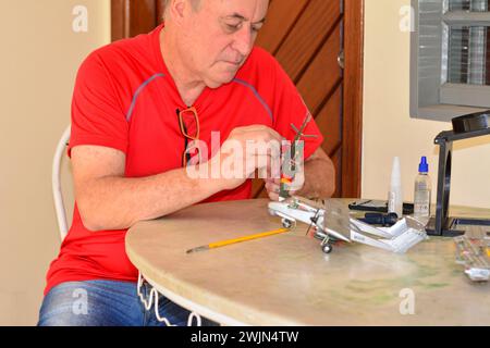 Kit de modèle en plastique, homme mettant la roue de train d'atterrissage sur le kit de modèle en plastique, Brésil, Amérique du Sud, mise au point sélective, zoom, recadrage intentionnel Banque D'Images