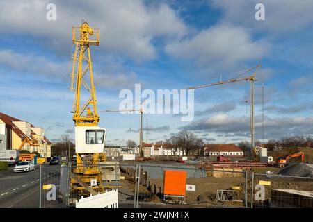 Début de l'assemblage d'une grue de construction sur un chantier de construction dans un quartier résidentiel. Banque D'Images