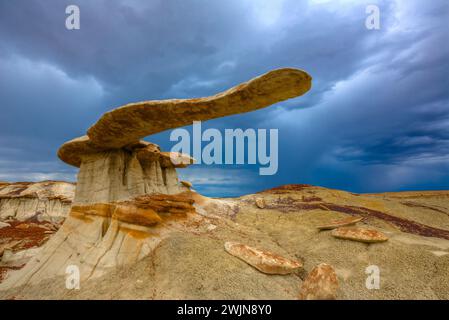 Le Roi des ailes, un hoodoo en grès très fragile dans les badlands du bassin de San Juan au Nouveau-Mexique, avec des nuages de tempête derrière. Banque D'Images