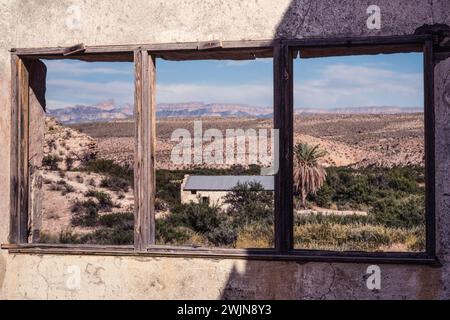 La fenêtre d'une vieille ruine à Hot Springs encadre le paysage désertique et l'ancien bureau de poste dans le parc national de Big Bend au Texas. La Sierra del Carmen Mo Banque D'Images