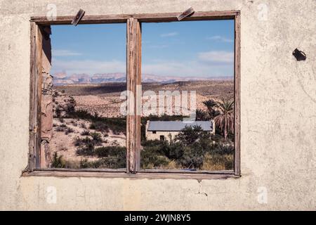 La fenêtre d'une vieille ruine à Hot Springs encadre le paysage désertique et l'ancien bureau de poste dans le parc national de Big Bend au Texas. La Sierra del Carmen Mo Banque D'Images