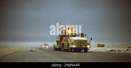 Première Guerre du Golfe : 12 mars 1991 dans le nord du Koweït, une colonne de camions de l'armée britannique se dirige vers le sud sous des nuages sombres de fumée provenant des puits de pétrole brûlés. Banque D'Images