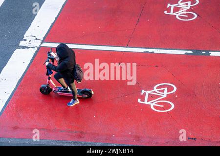 E-scooter, e-scooter sur la voie cyclable, aire de stationnement pour les cyclistes à un croisement de feux de circulation, marqué rouge, voitures, voitures, camions doivent s'arrêter derrière elle au rouge Banque D'Images