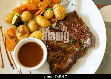 Plat dans un ancien bistro à Limoges, en France, steak de bœuf Limousin servi avec des potatos cuits au four, servi avec un bouillon léger ou de la sauce Banque D'Images