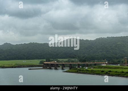 Canal de Panama, Panama - 24 juillet 2023 : pont Puente Chagres sur la rivière se vidant dans le lac Gatun près des écluses de Gatun sous un nuage gris avec forêt verte Banque D'Images