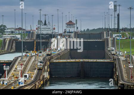 Canal de Panama, Panama - 24 juillet 2023 : cargo général de la Fairwind Legion dans les écluses de Gatun. Chambres multiples et leurs portes sous un nuage bleu Banque D'Images