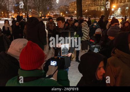 Prog Pétersbourg, Russie. 16 février 2024. Un homme tient des fleurs et un portrait du leader de l'opposition russe Alexei Navalny au monument des victimes de la répression politique à Pétersbourg. Crédit : SOPA images Limited/Alamy Live News Banque D'Images