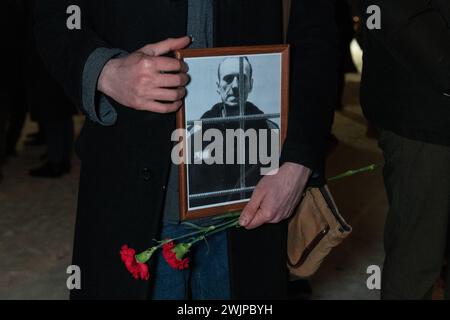 Prog Pétersbourg, Russie. 16 février 2024. Un homme tient des fleurs et un portrait du leader de l'opposition russe Alexei Navalny au monument des victimes de la répression politique à Pétersbourg. Crédit : SOPA images Limited/Alamy Live News Banque D'Images