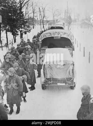 Les troupes aéroportées américaines en Belgique se préparent à se déplacer -- les hommes de la 82ème Division aéroportée font la queue pour barder les camions le long d'une route enneigée quelque part en Belgique. Ces troupes, sous le commandement du major-général James Savin, âgé de 37 ans, ont participé aux combats en Sicile et sur le continent italien et ont fait partie des forces américaines débarquées en Normandie 'jour J' (6 juin 1944). Au cours de la course à Arnhem, en Hollande, ils se distinguent en capturant et en tenant des ponts essentiels à l'avancée des forces alliées. 26 février 1945. (Photo par U. S. signal corps). Banque D'Images