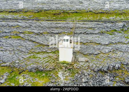 Black Head Lighthouse, situé dans le paysage rocheux rugueux de Burren, au milieu d'un paysage bizarre de montagnes calcaires escarpées et de côtes rocheuses, cou Banque D'Images