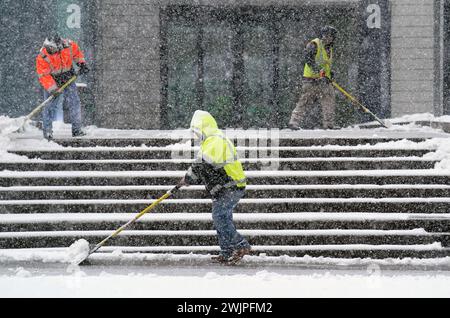 Prog Louis, États-Unis. 16 février 2024. Les ouvriers utilisent des pelles pour déneiger les escaliers d'un immeuble de bureaux du centre-ville Louis le vendredi 16 février 2024. La neige commence à tomber pendant l'heure de pointe du matin, déversant jusqu'à six pouces de neige sur le secteur jusqu'à l'arrêt en fin d'après-midi. Photo de Bill Greenblatt/UPI crédit : UPI/Alamy Live News Banque D'Images