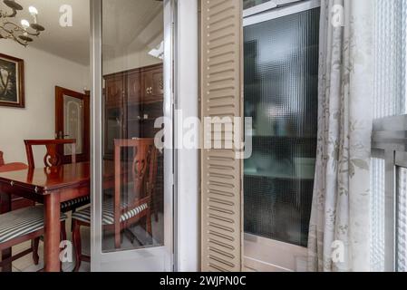 Petite terrasse avec portes en aluminium et volets en verre et fer peints en brun clair Banque D'Images