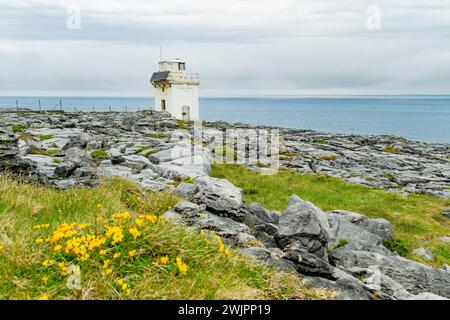 Black Head Lighthouse, situé dans le paysage rocheux rugueux de Burren, au milieu d'un paysage bizarre de montagnes calcaires escarpées et de côtes rocheuses, cou Banque D'Images