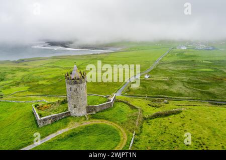 Vue aérienne du château de Doonagore, tour ronde du XVIe siècle avec une petite enceinte murée située près du village côtier de Doolin dans le comté de CLA Banque D'Images