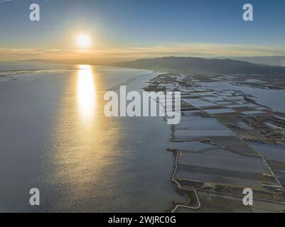 Vue aérienne de la baie d'Alfacs et des rizières sur un coucher de soleil hivernal dans le delta de l'Èbre (Tarragone, Catalogne, Espagne) Banque D'Images