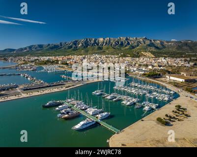 Vue aérienne de la ville de la Ràpita et de son port au premier plan. En arrière-plan, la chaîne de montagnes Montsià (Tarragone, Catalogne, Espagne) Banque D'Images