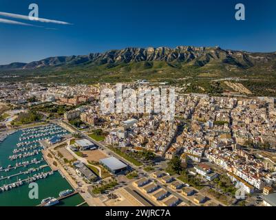 Vue aérienne de la ville de la Ràpita et de son port au premier plan. En arrière-plan, la chaîne de montagnes Montsià (Tarragone, Catalogne, Espagne) Banque D'Images