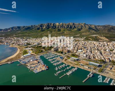 Vue aérienne de la ville de la Ràpita et de son port au premier plan. En arrière-plan, la chaîne de montagnes Montsià (Tarragone, Catalogne, Espagne) Banque D'Images