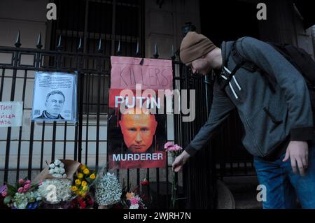 New York, États-Unis. 16 février 2024. Un démonstrateur place des fleurs lors d'une veillée pour Alexei Navalny. La veillée a eu lieu devant le consulat général de la Fédération de Russie dans l'arrondissement de Manhattan à New York. Selon un rapport du service pénitentiaire russe, Alexei Navalny, ancien avocat et critique de Vladimir Poutine, est mort en prison dans une colonie pénitentiaire russe au nord du cercle arctique. Le président américain Joe Biden a blâmé Poutine pour la mort de Navalny. Navalny purgeait une peine combinée de plus de 30 ans de prison. Crédit : SOPA images Limited/Alamy Live News Banque D'Images