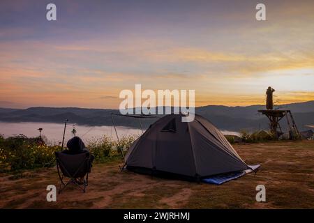 Tente touristique sur le site de camping sur la prairie à côté du brouillard pendant le coucher du soleil, Thaïlande. Beau coucher de soleil ciel crépusculaire Banque D'Images