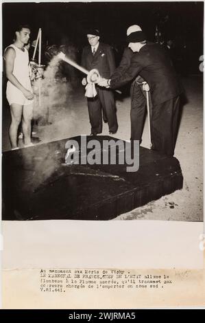 Service photographique central (SCP). 'Photographie de propagande : Maréchal Pétain allumant une torche, un monument aux morts de Vichy'. Au monument mort de Vichy. / Le Maréchal de France, chef de l’Etat allume la torche / avec la flamme sacrée, qu’il transmet aux coureurs responsables de la victoire dans la zone sud. / V.81.441. Tirage au bromure de gélatino-argent. Légende dactylographiée à l'encre noire. en 1943-1943. Paris, musée Carnavalet. 144783-18 Banque D'Images