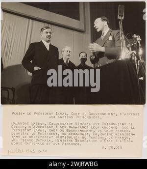 Trampus. 'Photographie de propagande : le président Laval s'apprête à faire un discours devant les anciens prisonniers, Paris'. Paris, le Président Laval, chef du gouvernement, s’adresse / anciens prisonniers. / M. André Masson, commissaire général aux prisonniers de guerre, s'adressant à ses camarades annonce que le / Président Laval, chef du gouvernement, leur parlera. / Derrière le président, nous reconnaissons, M. racine représente- / à la fois le secrétariat particulier du Maréchal de France, / M. Pierre Cathala, secrétaire d’État à Eco- / nomie nationale et aux Finances. Gélatino-bromure d'argent dr. Banque D'Images